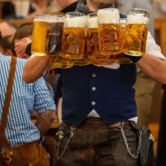 Un serveur porte plusieurs chopes de bière mousseuse lors de l'October Fest.