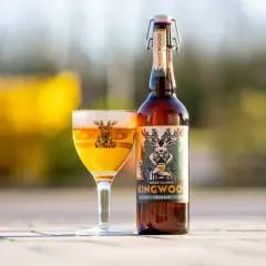 Une bière blonde Kingwood, une bière welsh, est servie dans un verre avec un cerf sur l'étiquette.