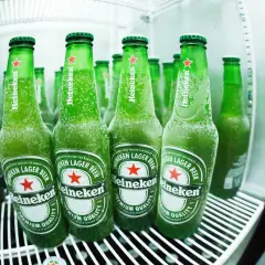 Des bouteilles de bière Heineken, givrées et prêtes à être dégustées, évoquant l'origine et la fraîcheur de la marque.