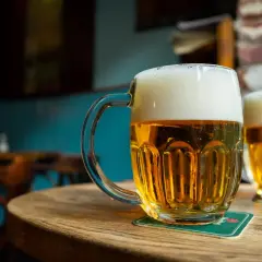 Deux chopes de bière pression mousseuse sur une table en bois. Le prix d'une bière pression est raisonnable pour ce moment de détente.