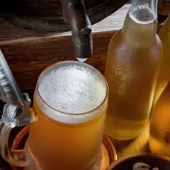 Bière fraîche dans un chopes et bouteilles, rappelant le processus de fermentation.
