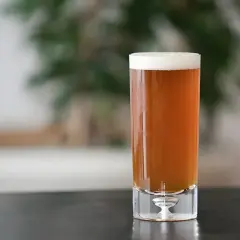 Un verre de bière ambrée, parfaite pour une recette de pale ale maison. La mousse blanche couronne la boisson.