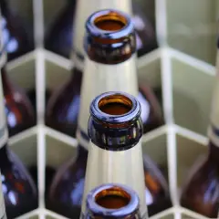 Bouteilles de bière brune française alignées dans un casier. Le col des bouteilles est visible, prêt à être dégusté.