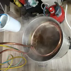 Préparation d'une bière artisanale avec un système de whirlpool. Le moût bouillonne dans la cuve en inox, traversé par un serpentin en cuivre.