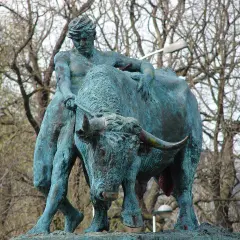 Sculpture d'un homme luttant avec un taureau, évoquant la force brute, comme le **logo Jupiler**.