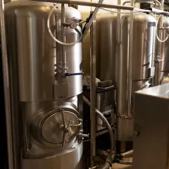 Cuves en acier inoxydable pour la fermentation de bière, avec manomètres et vannes. La température est cruciale pour une bonne fermentation.