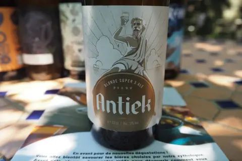 Une blonde française, la bière Antiek, sur une table ensoleillée.