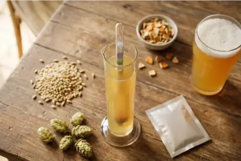 Kit de brassage artisanal : malt, houblon, levure, hydromètre pour un test iode bière parfait. Une bière dorée mousseuse à déguster.