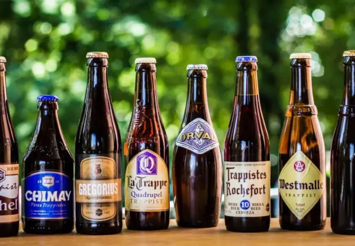 Une sélection de 7 bières trappistes belges alignées : Achel, Chimay, Gregorius, La Trappe, Orval, Rochefort, Westmalle.