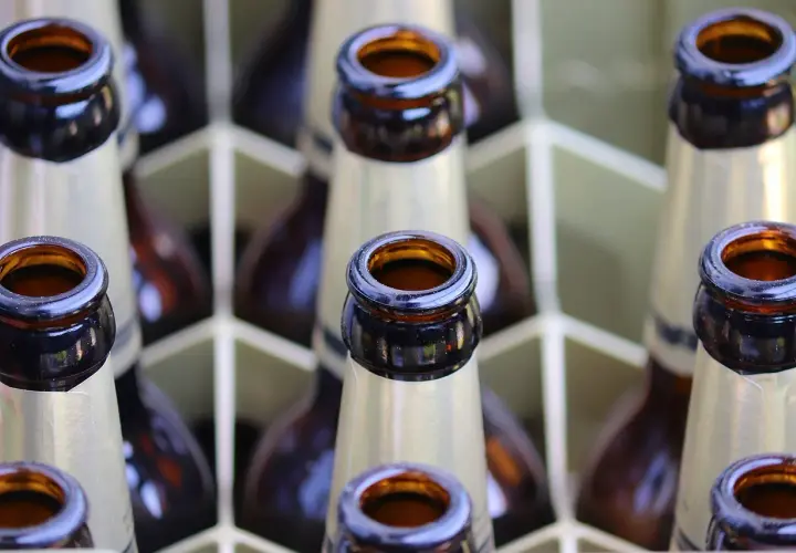 Bouteilles de bière brune française alignées dans un casier. Le col des bouteilles est visible, prêt à être dégusté.