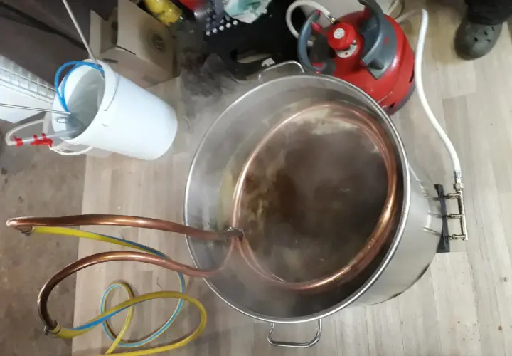 Préparation d'une bière artisanale avec un système de whirlpool. Le moût bouillonne dans la cuve en inox, traversé par un serpentin en cuivre.