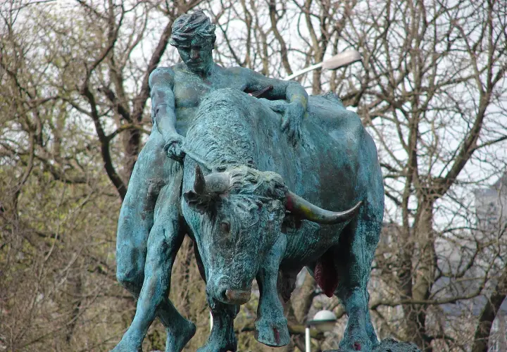 Sculpture d'un homme luttant avec un taureau, évoquant la force brute, comme le **logo Jupiler**.