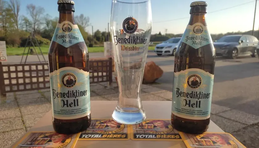 Deux bouteilles de Benediktiner Hell et un verre vide, prêts pour déguster la meilleure bière allemande.