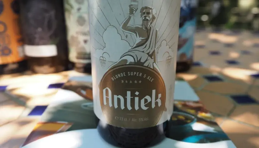 Une blonde française, la bière Antiek, sur une table ensoleillée.