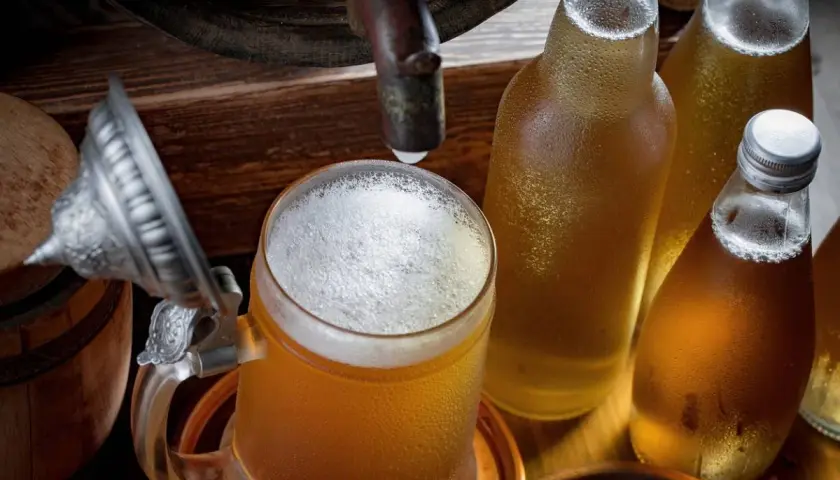 Bière fraîche dans un chopes et bouteilles, rappelant le processus de fermentation.