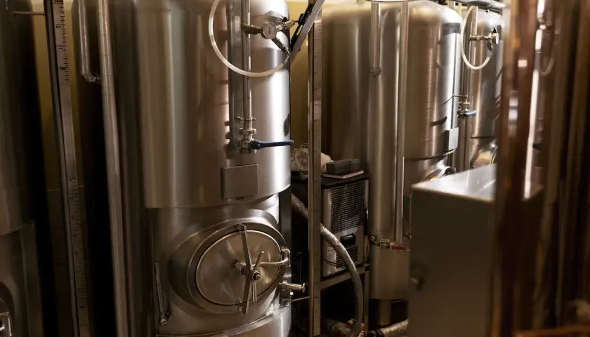 Cuves en acier inoxydable pour la fermentation de bière, avec manomètres et vannes. La température est cruciale pour une bonne fermentation.