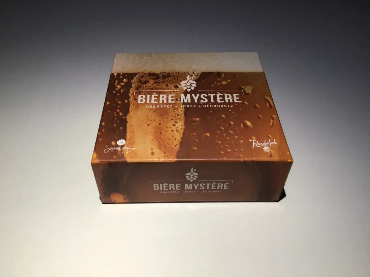 Boîte de jeu "Bière Mystère" avec une illustration de bière mousseuse. Parfait pour une soirée biere 80.