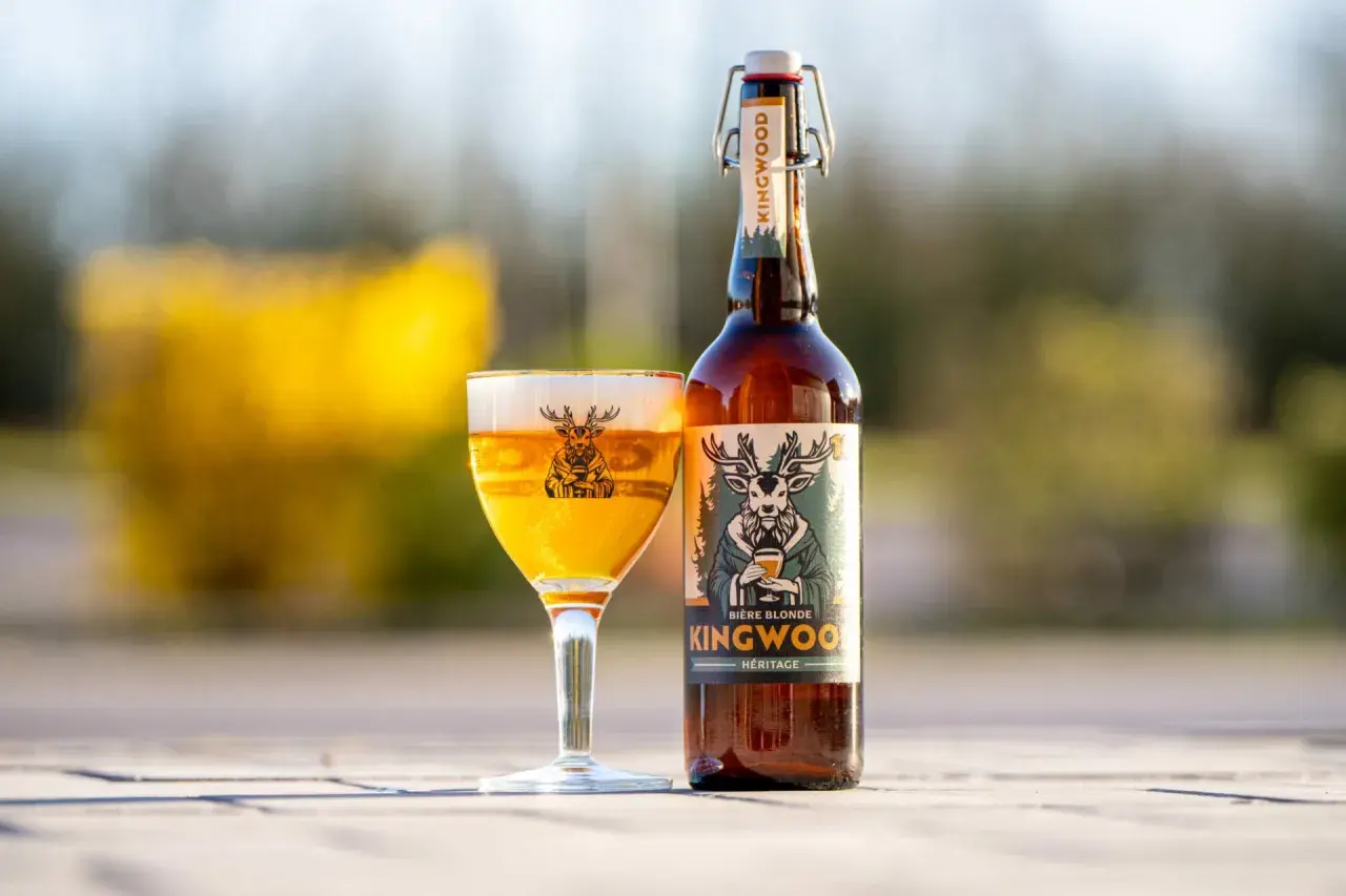 Une bière blonde Kingwood, une bière welsh, est servie dans un verre avec un cerf sur l'étiquette.