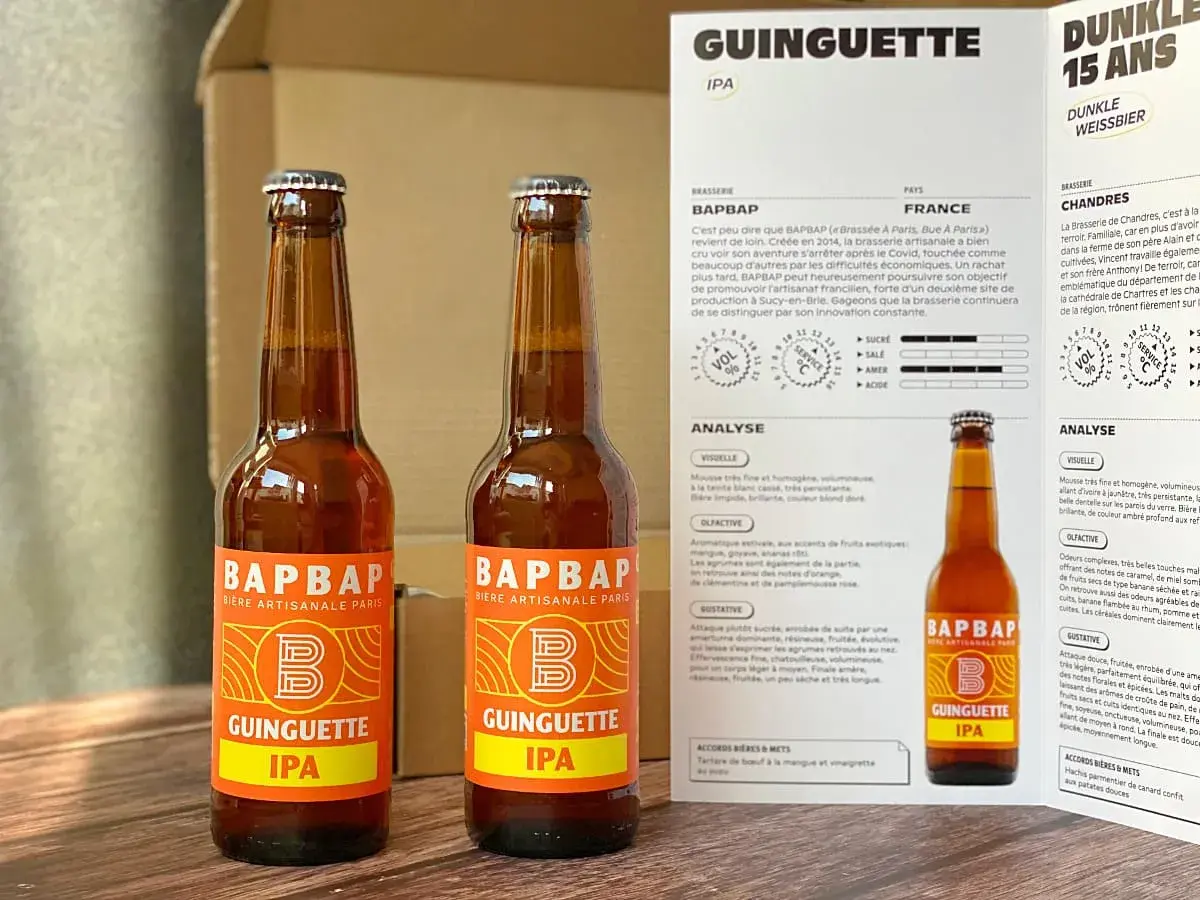 Deux bouteilles de bière artisanale "Guinguette IPA" de BAPBAP. Une bière qui fait penser à un hibou, avec son nom et son logo audacieux.