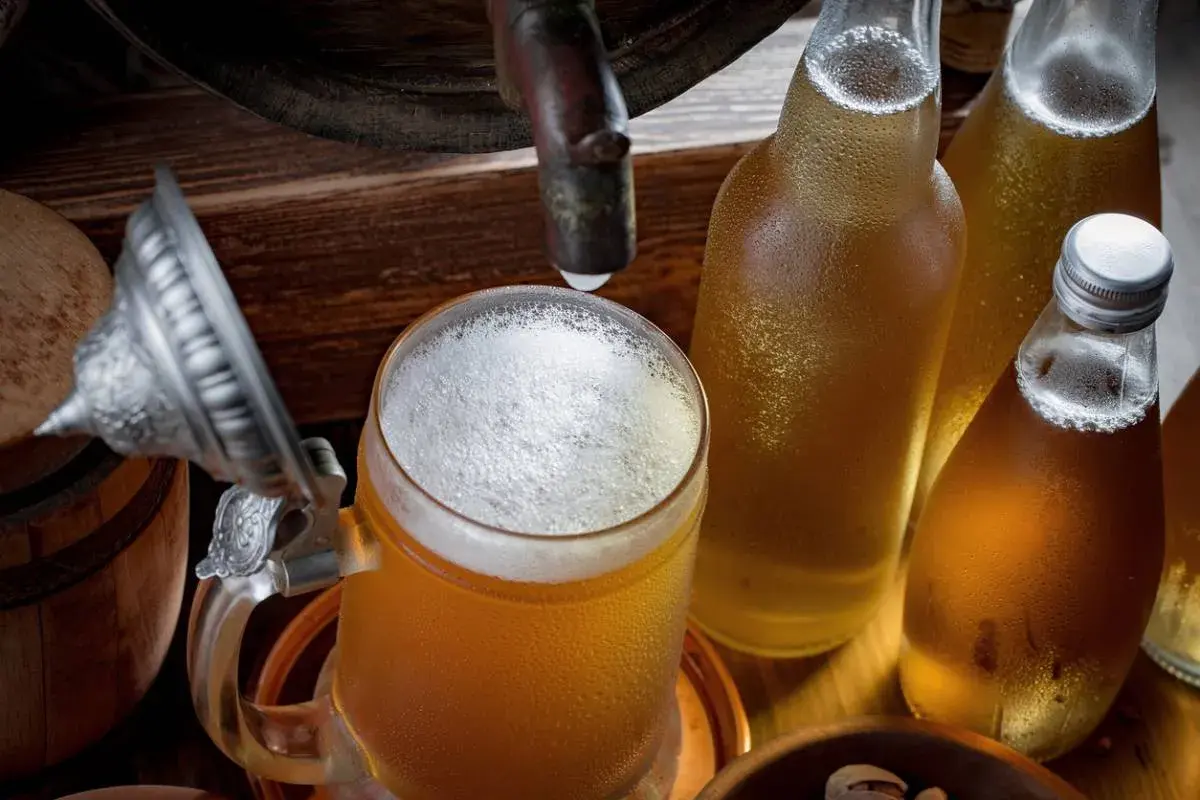 Bière fraîche dans un chopes et bouteilles, rappelant le processus de fermentation.