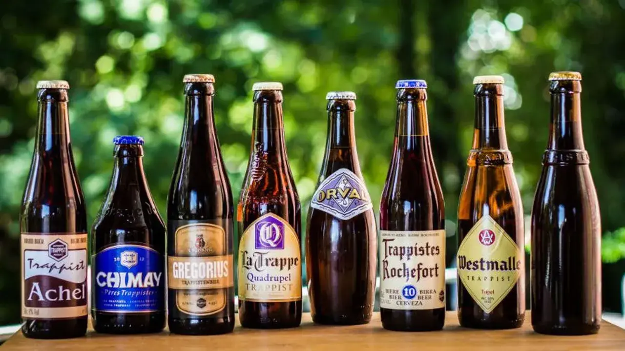 Une sélection de 7 bières trappistes belges alignées : Achel, Chimay, Gregorius, La Trappe, Orval, Rochefort, Westmalle.