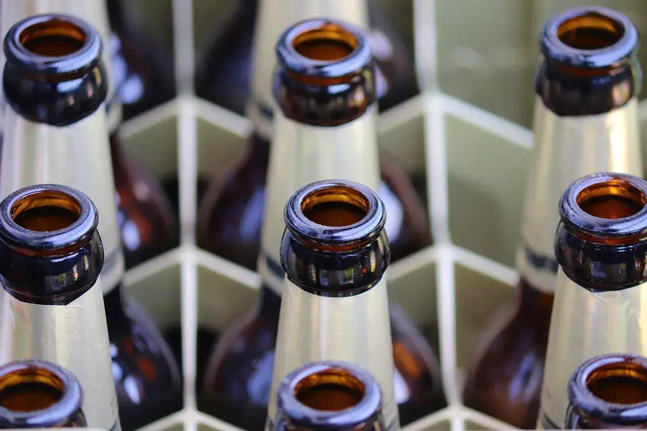 Bouteilles de bière brune française alignées dans un casier. Le col des bouteilles est visible, prêt à être dégusté.