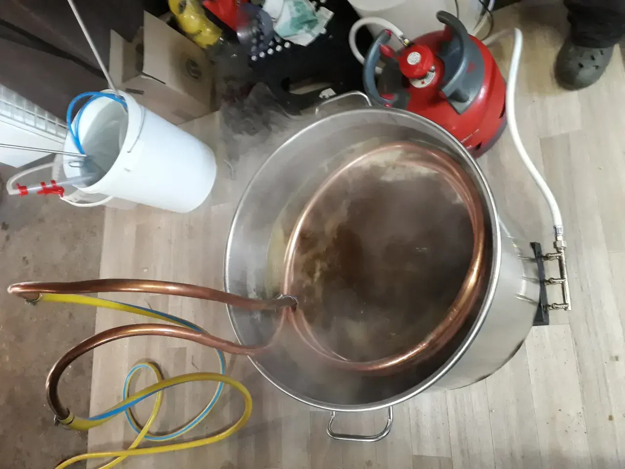 Préparation d'une bière artisanale avec un système de whirlpool. Le moût bouillonne dans la cuve en inox, traversé par un serpentin en cuivre.