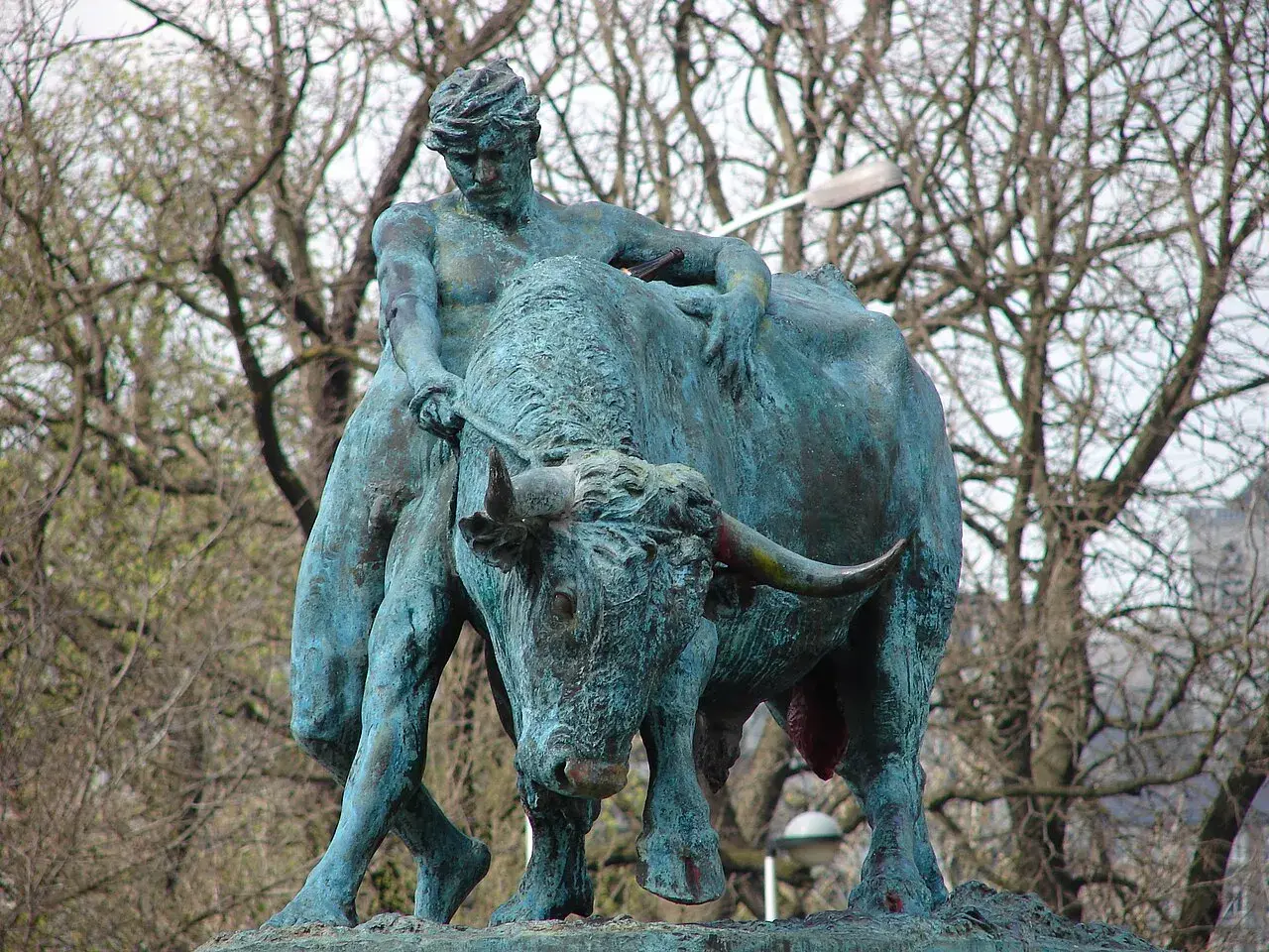 Sculpture d'un homme luttant avec un taureau, évoquant la force brute, comme le **logo Jupiler**.