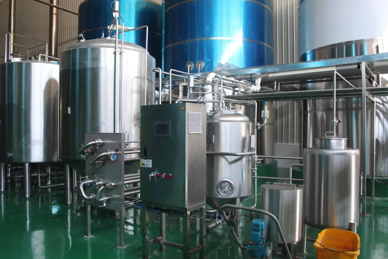 Installation industrielle pour la fabrication de levure de bière, avec de grandes cuves en acier inoxydable et des tuyauteries complexes.