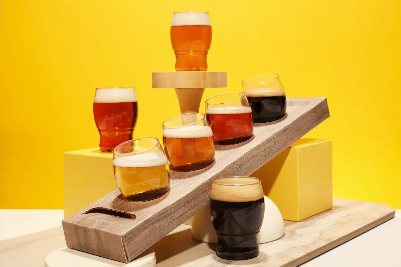 Dégustation de bières américaines : plusieurs verres de différentes couleurs, allant de la blonde à la brune, sont disposés sur des supports.