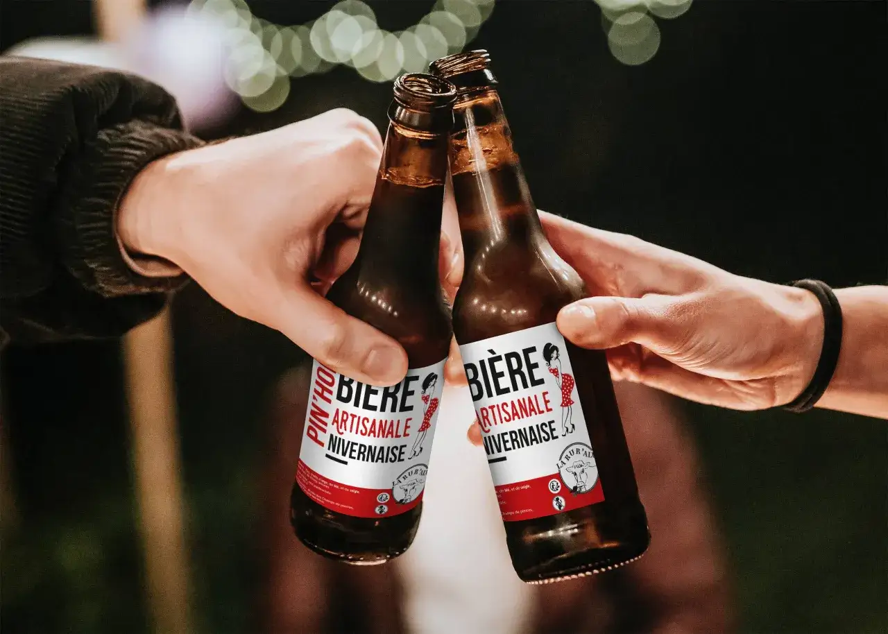Deux mains portent des bouteilles de bi&egrave;re artisanale non pasteuris&eacute;e. Une liste de bi&egrave;res non pasteuris&eacute;es &agrave; d&eacute;couvrir.