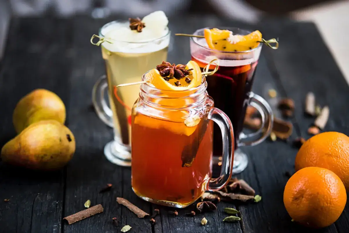 Trois boissons chaudes r&eacute;confortantes, dont une bi&egrave;re chaude &eacute;pic&eacute;e, garnies d'oranges et d'anis &eacute;toil&eacute;, sur fond de poires et d'&eacute;pices.