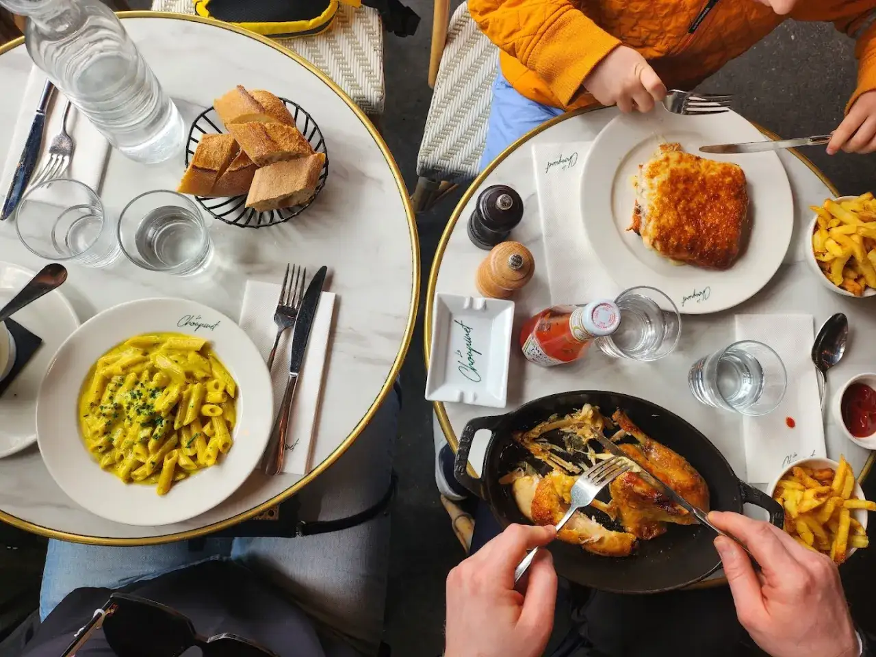 Repas convivial dans une brasserie fran&ccedil;aise : poulet r&ocirc;ti, p&acirc;tes &agrave; la cr&egrave;me, croque-monsieur et frites.