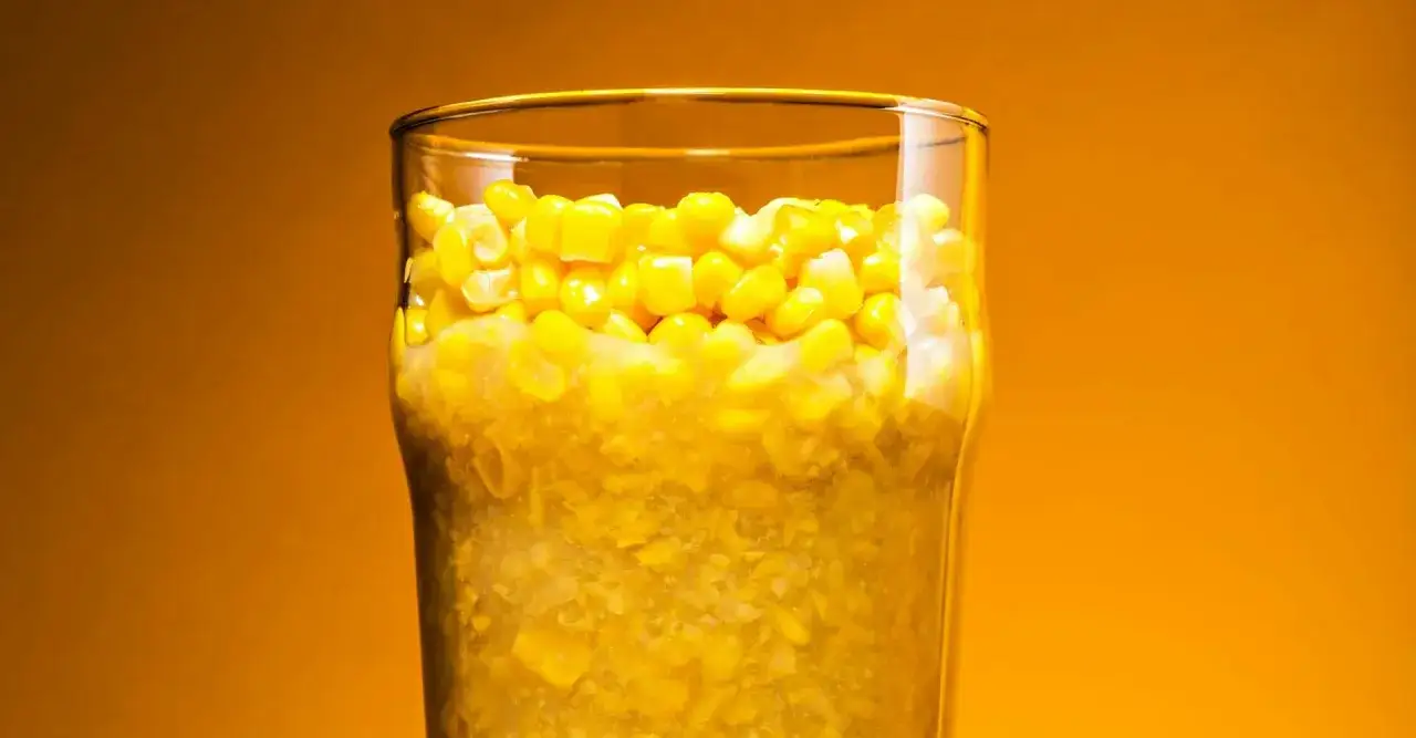 Verre rempli de grains de ma&iuml;s, rappelant une bi&egrave;re artisanale aux dms.