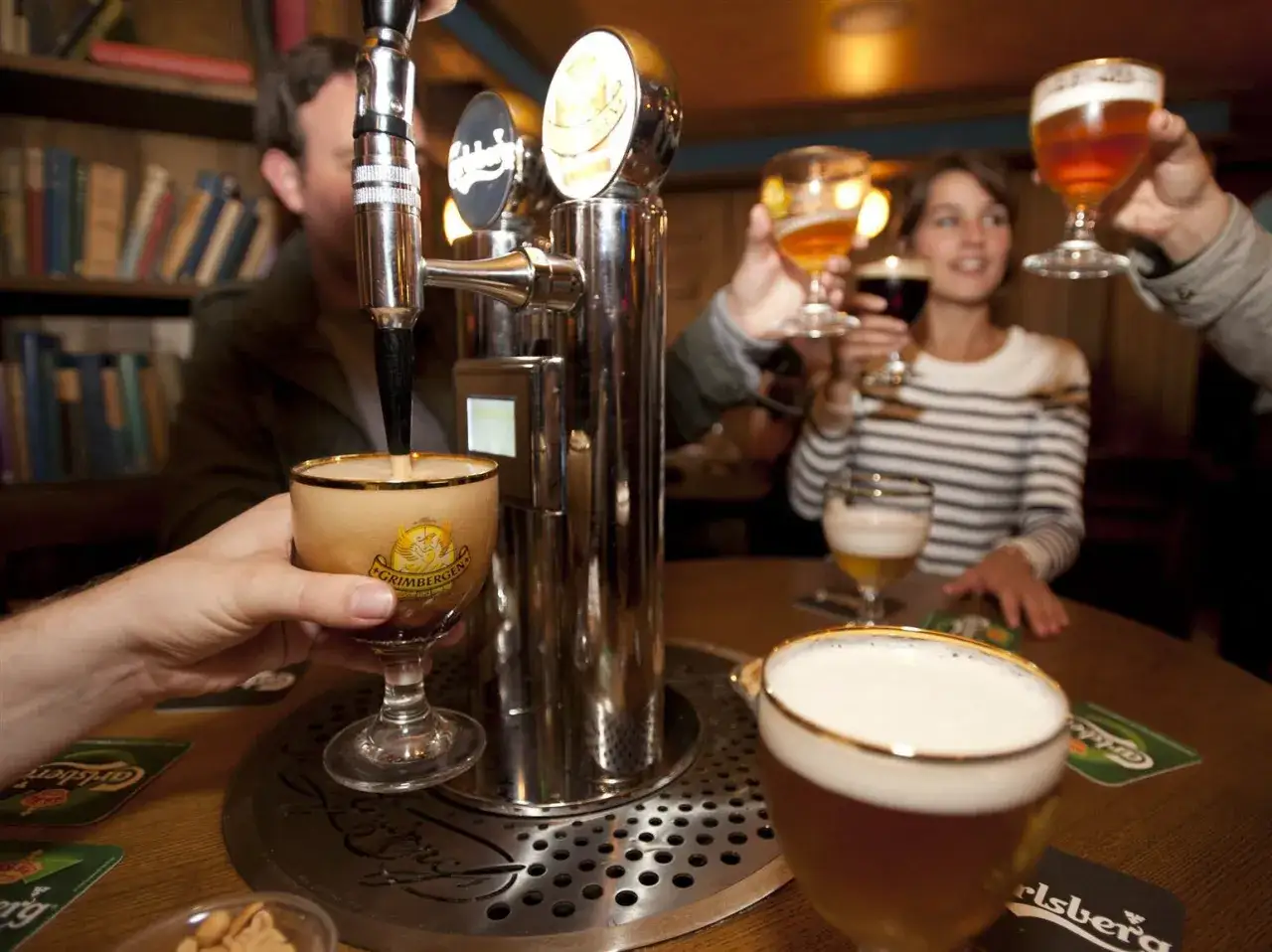 Un homme sert une bi&egrave;re pression dans un pub. Le prix d'une bi&egrave;re pression est raisonnable pour cette ambiance conviviale.