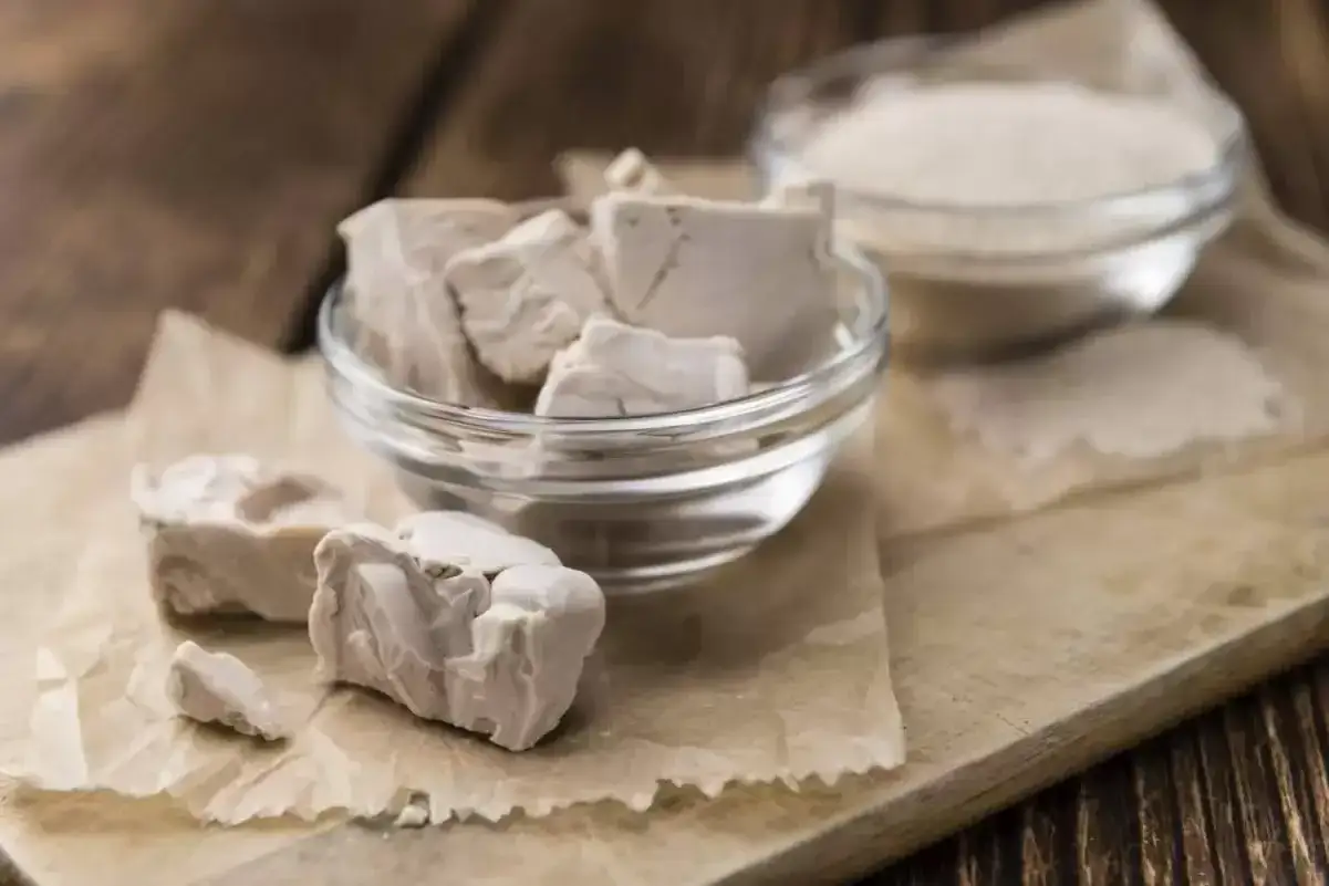 Blocs de levure fra&icirc;che p&eacute;rim&eacute;e dans un bol en verre, pr&ecirc;ts &agrave; &ecirc;tre jet&eacute;s.