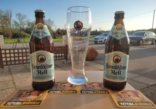 Deux bouteilles de Benediktiner Hell et un verre vide, prêts pour déguster la meilleure bière allemande.